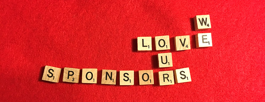 Scrabble blocks arranged on a red background to read 'we love our sponsors'